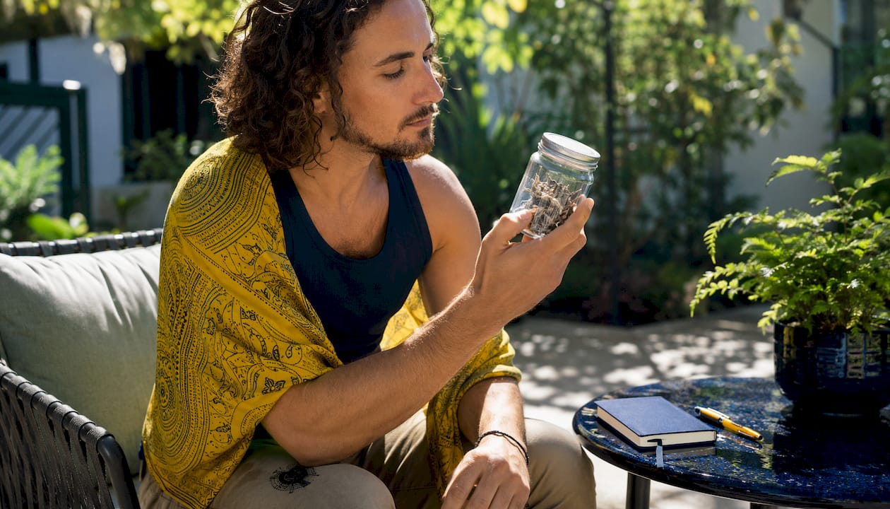 Person examining jar of dried mushrooms in living room