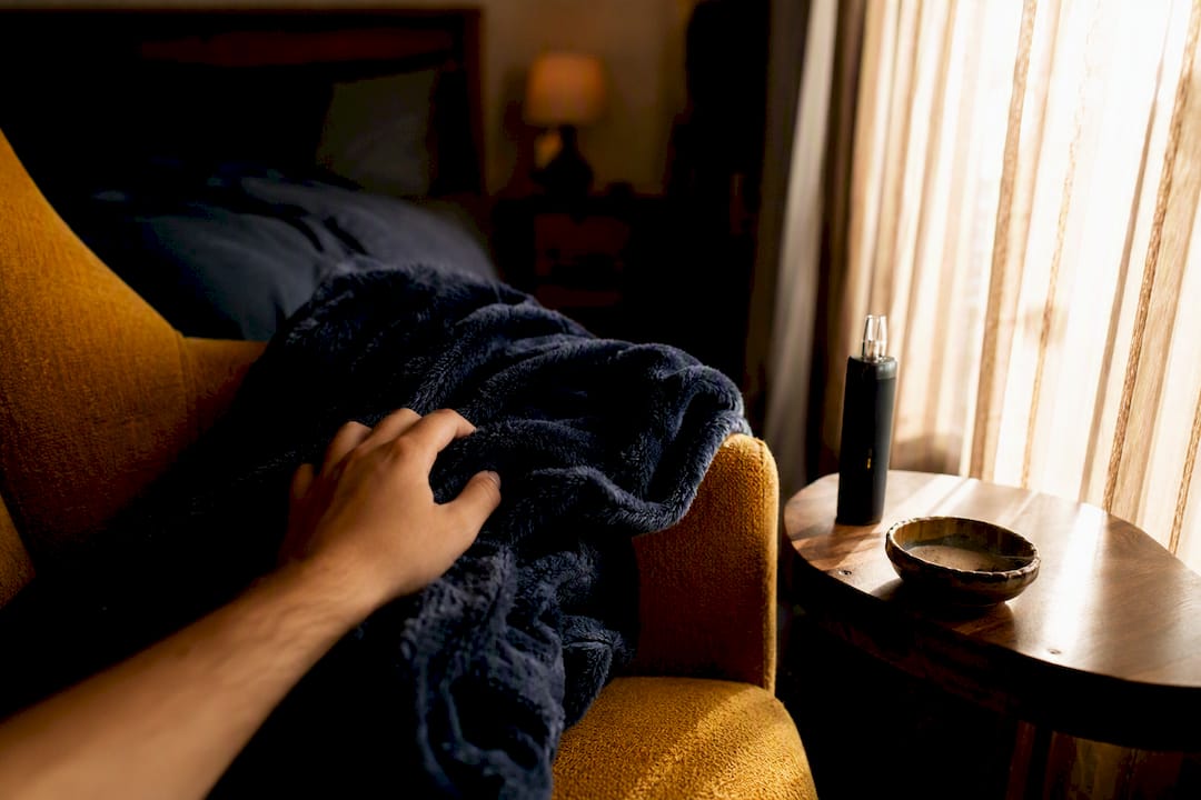 Relaxed hand reaching for couch pillow in cozy home corner