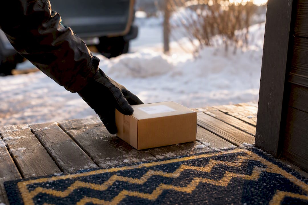 Courier placing discreet cannabis package at doorstep