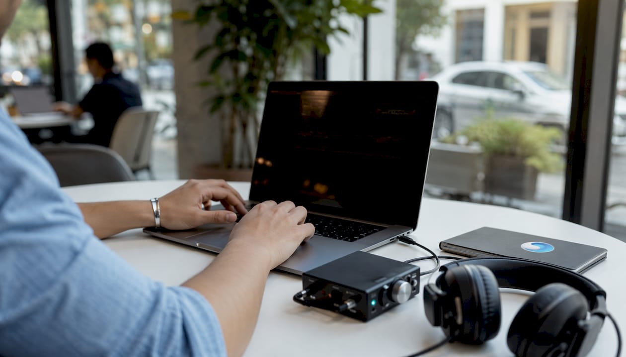 Hands editing audio waveforms at home desk