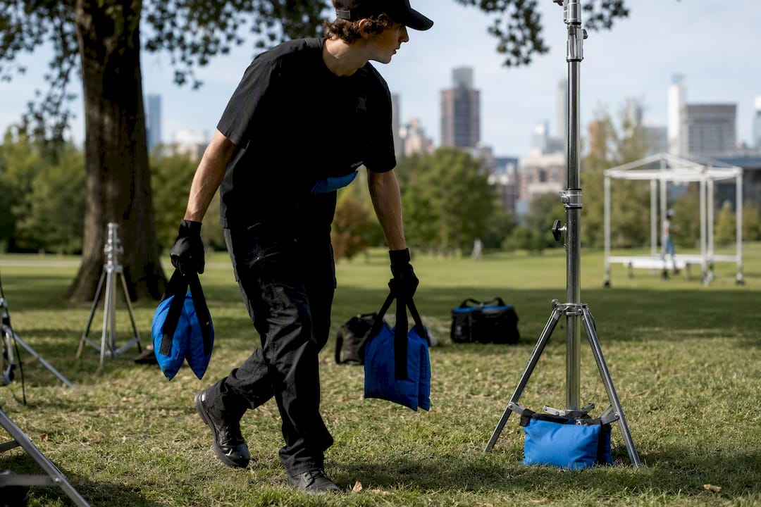 Film crew members securing sandbags on a set