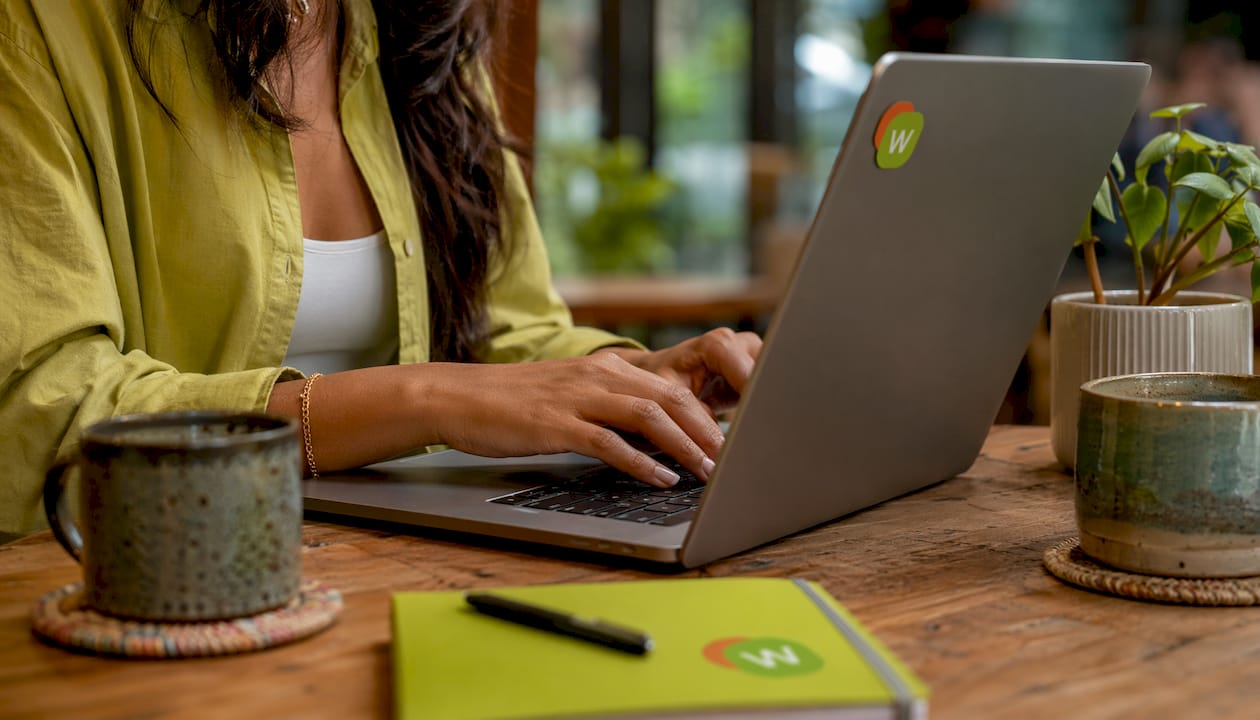Hands typing vocabulary tracking on laptop