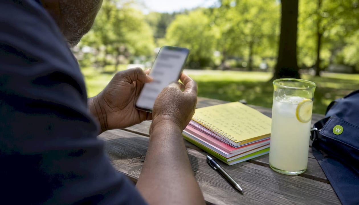Hands holding smartphone with flashcard app in café