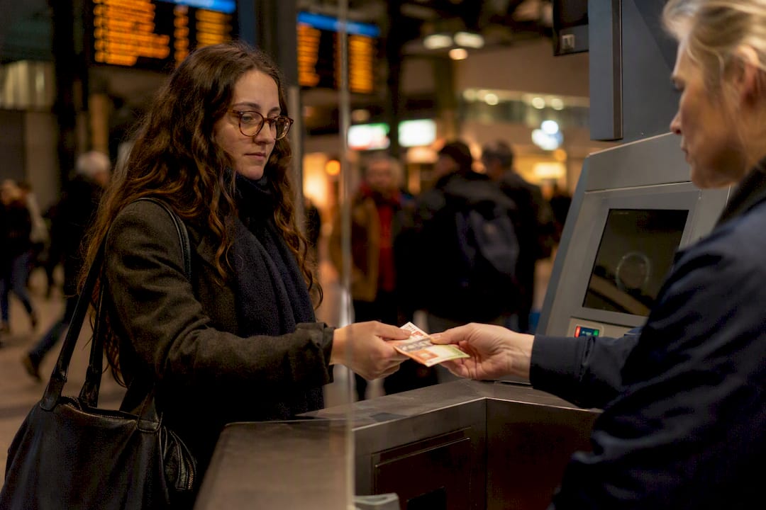 Hands paying cash for bus ticket