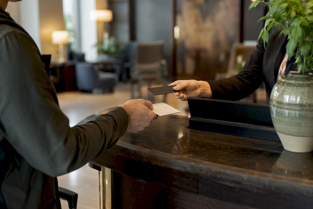 Hands exchanging hotel key card at desk