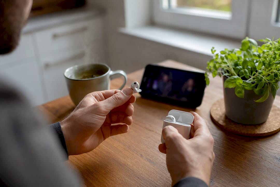 Hands adjusting earbuds preparing to watch subtitled video