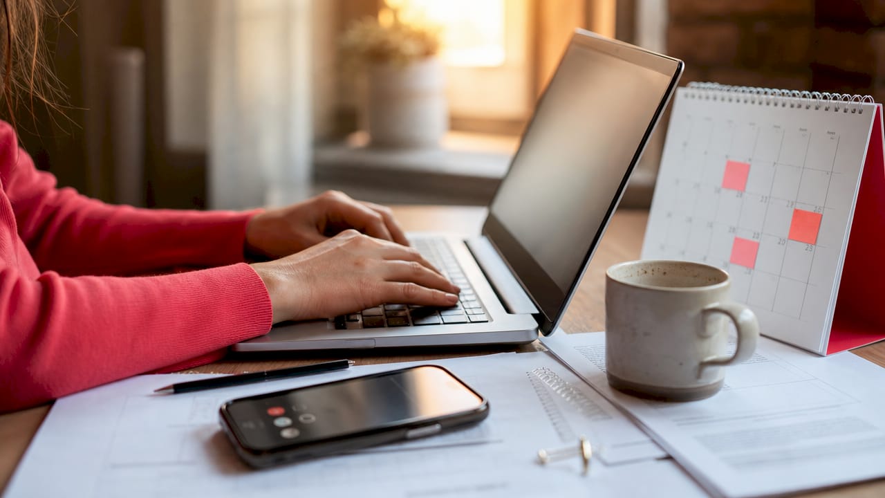 Hands typing at home office desk managing rental tasks