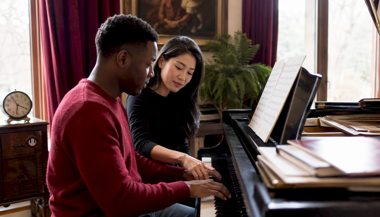 Hands playing piano keys closely