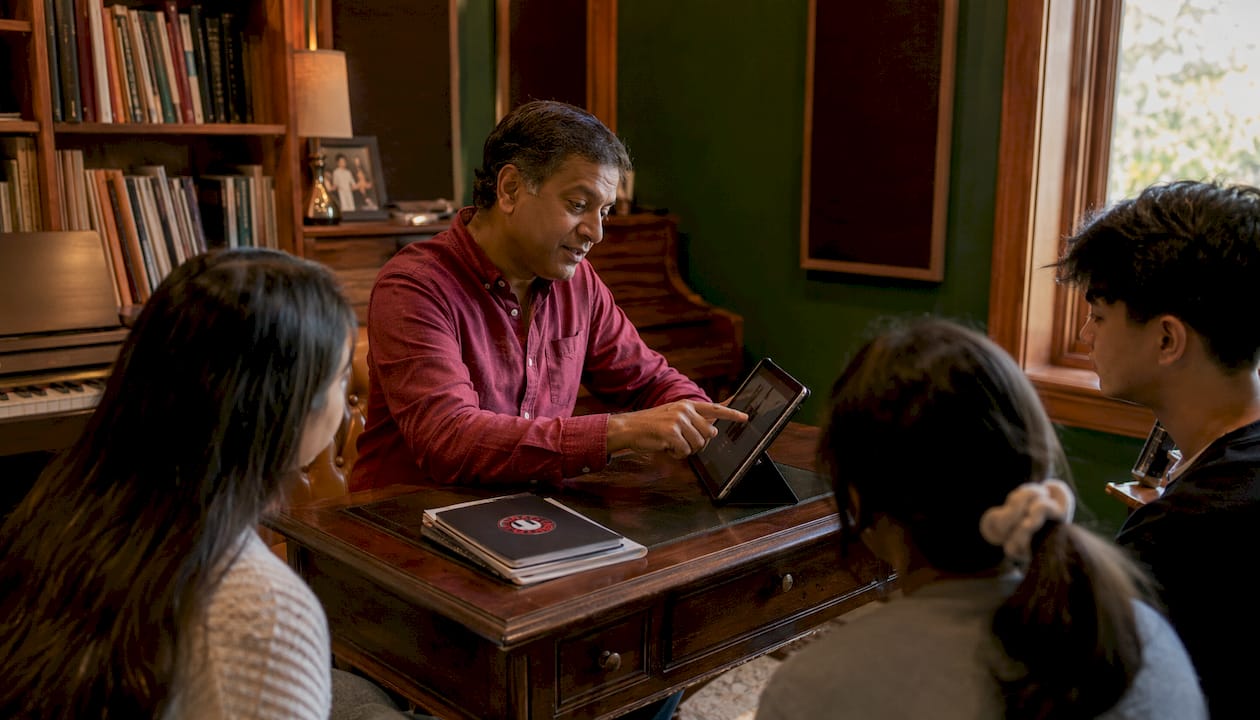 Music teacher showing tablet app to students