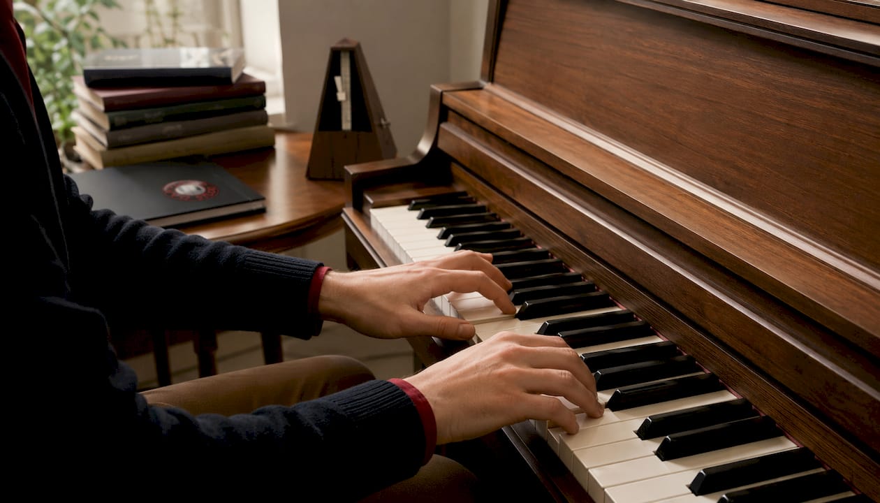 Hands demonstrating shell voicings on piano keys