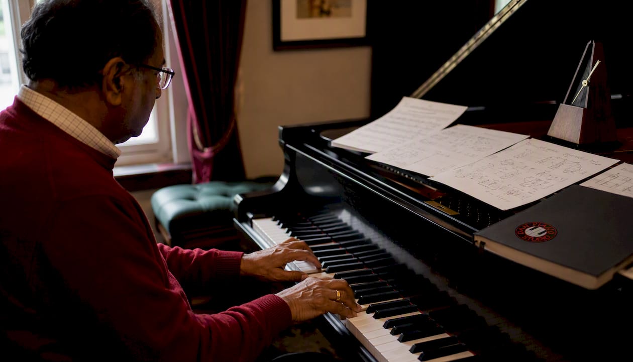 Hands forming piano chords on keyboard