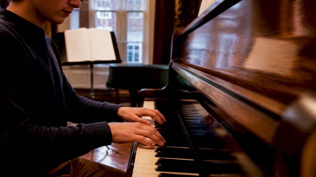 Student clapping rhythmic echoes at piano