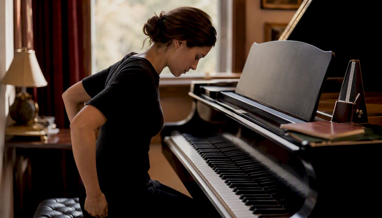 Pianist preparing at grand piano in warm room