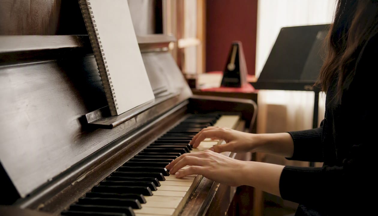Hands playing beginner jazz piano tune