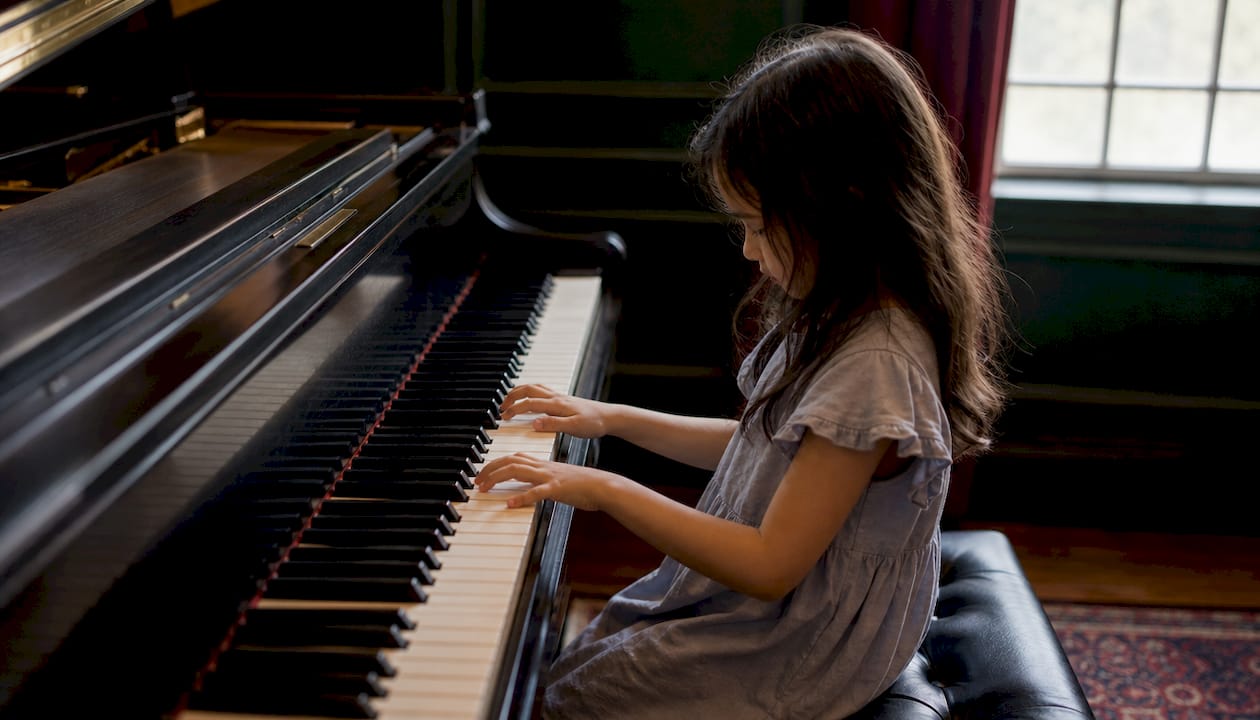 Small hands on piano keyboard close-up