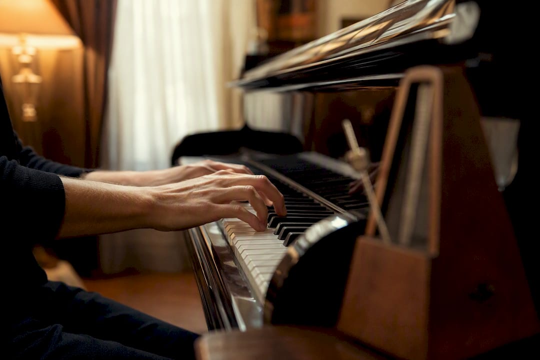 Hands practicing piano comping with metronome