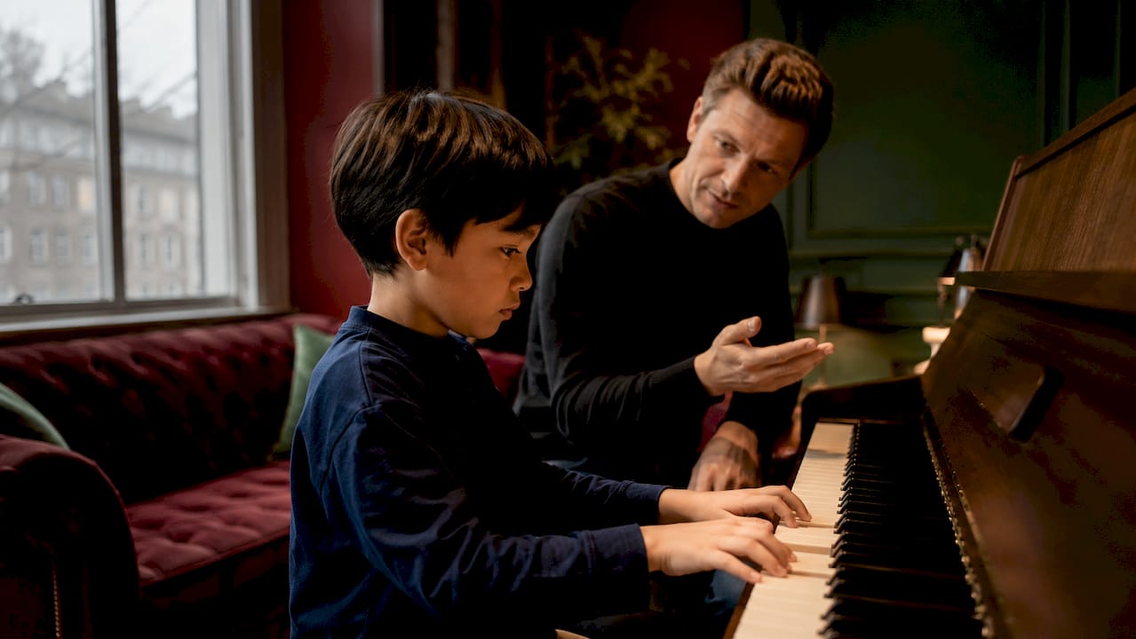 Child receiving calm support during piano lesson