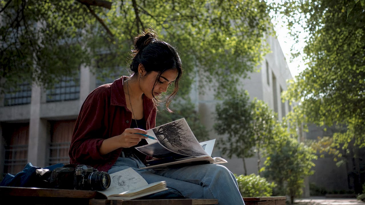 Student reviewing printed photography submissions