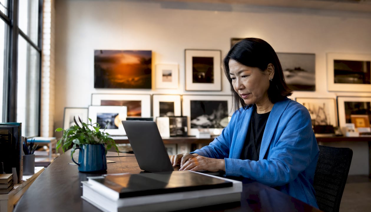 Curator composing email at gallery reception desk