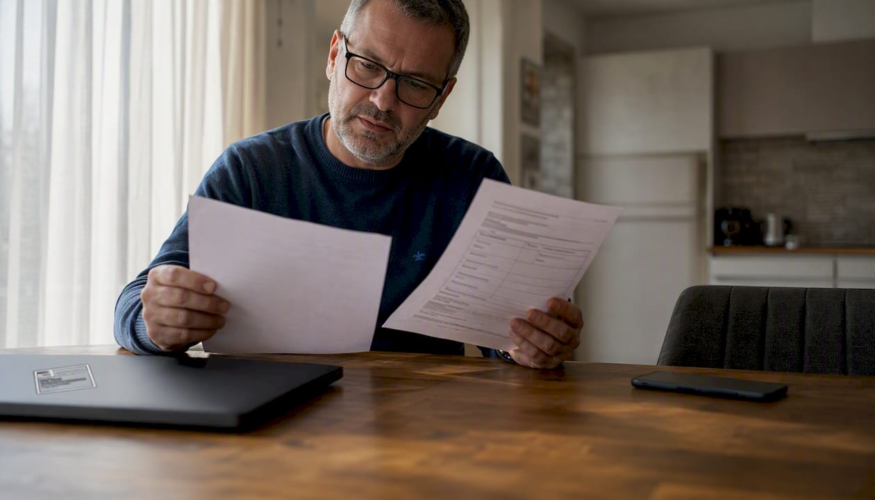 Man reviewing contest legitimacy documents at office desk