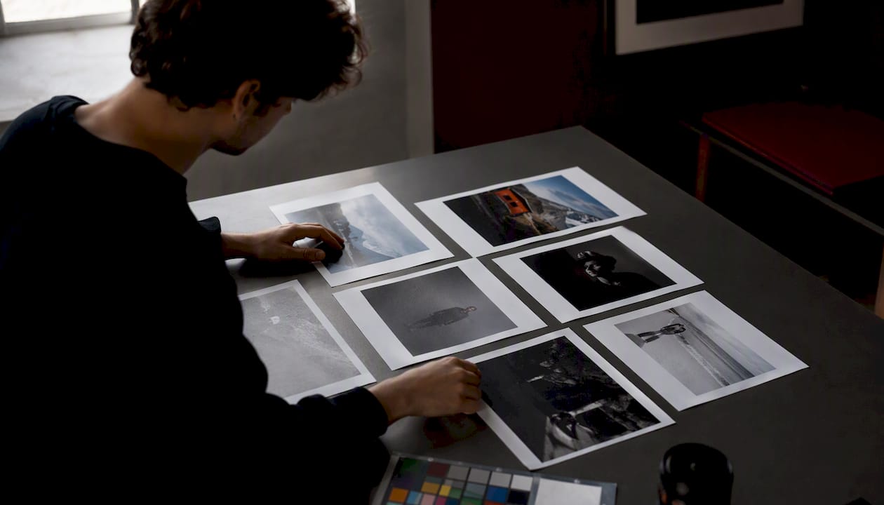 Manos seleccionando y organizando una serie de fotografías para un concurso