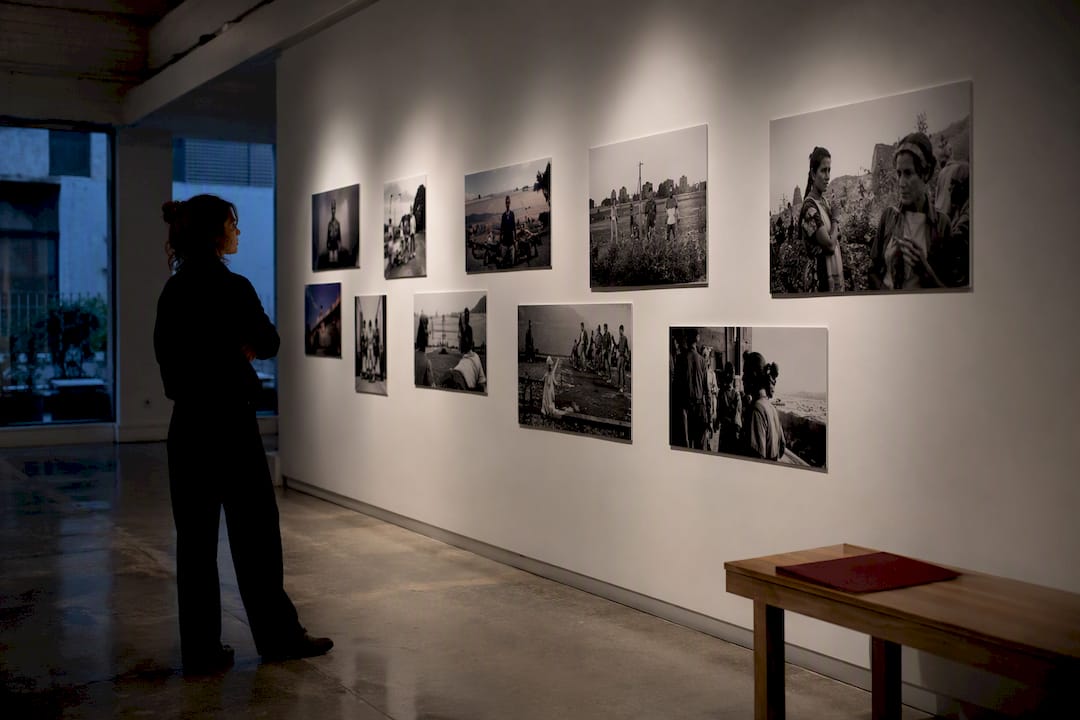 Fotógrafa mirando una serie documental en una galería