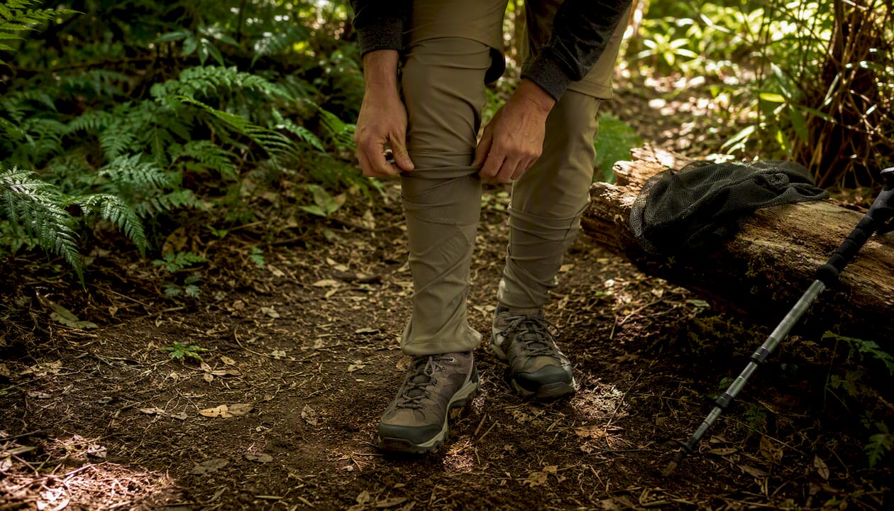 Backpacker adjusting mesh protective pants