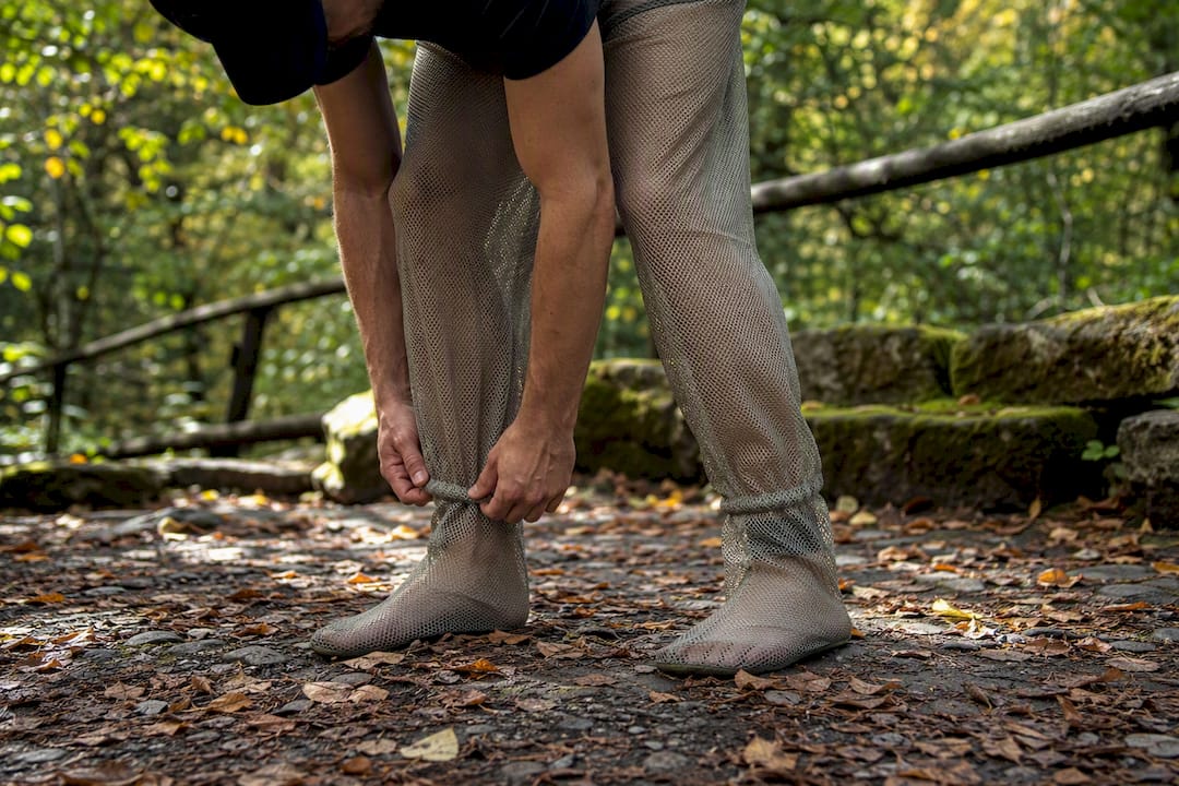 Person adjusting mesh protective pants outdoors