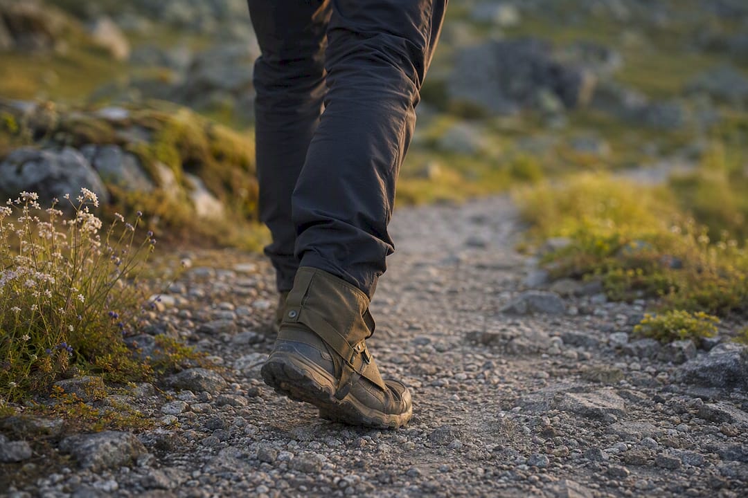 Hiker legs wearing slim pants and low gaiters on trail