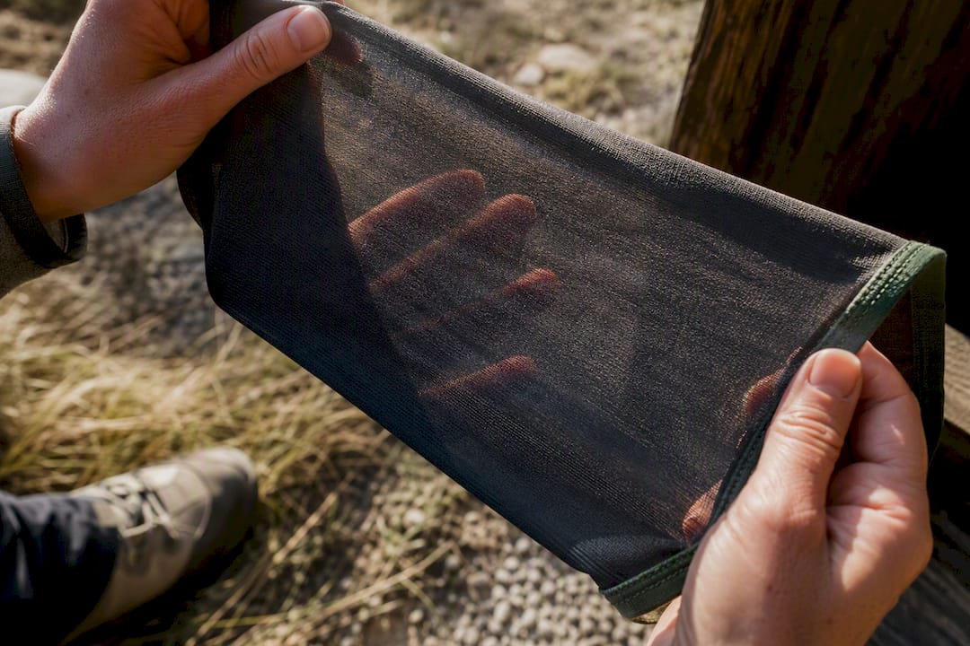 Hands checking sheer leggings against sunlight