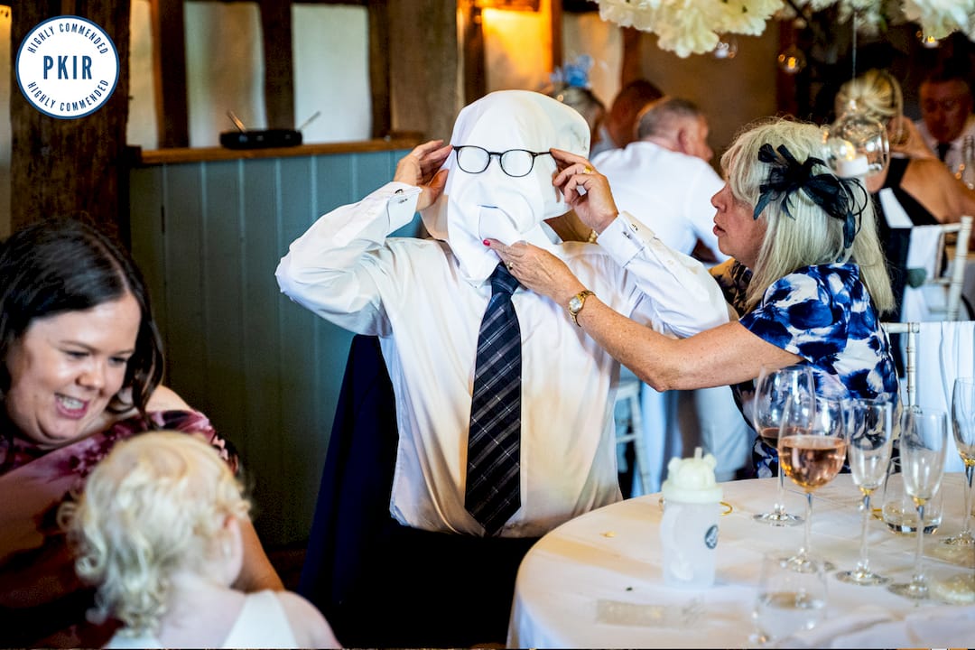 Photographer adjusting camera lens at outdoor wedding