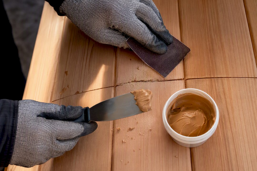 Hands repairing a cracked cedar sauna stave