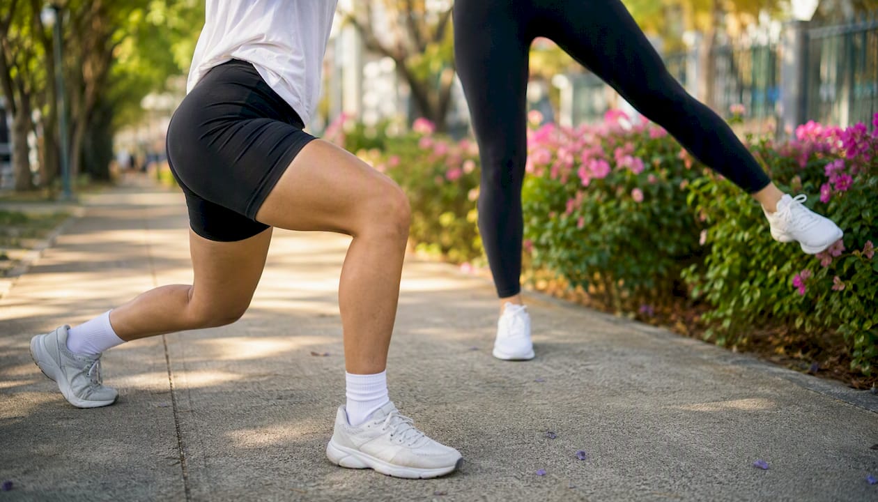 Woman doing calf raises by park bench