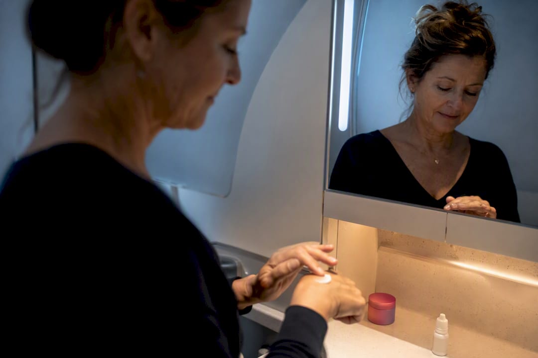 Traveler applying moisturizer during flight