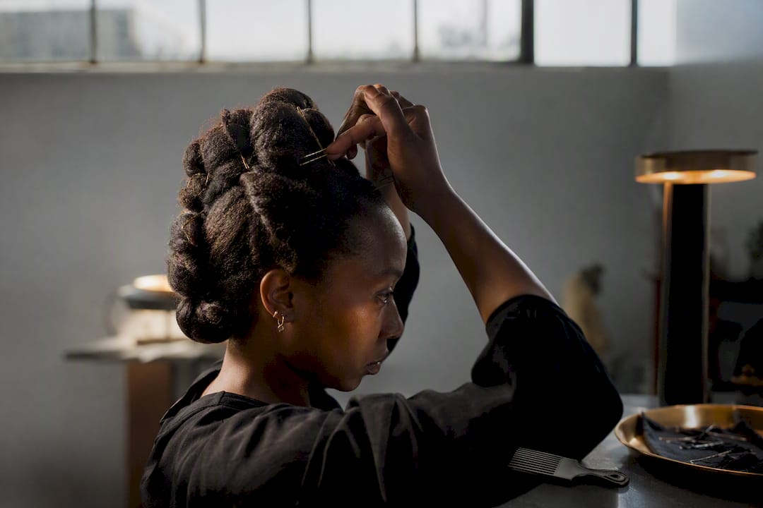 Artist constructing sculptural hair performance