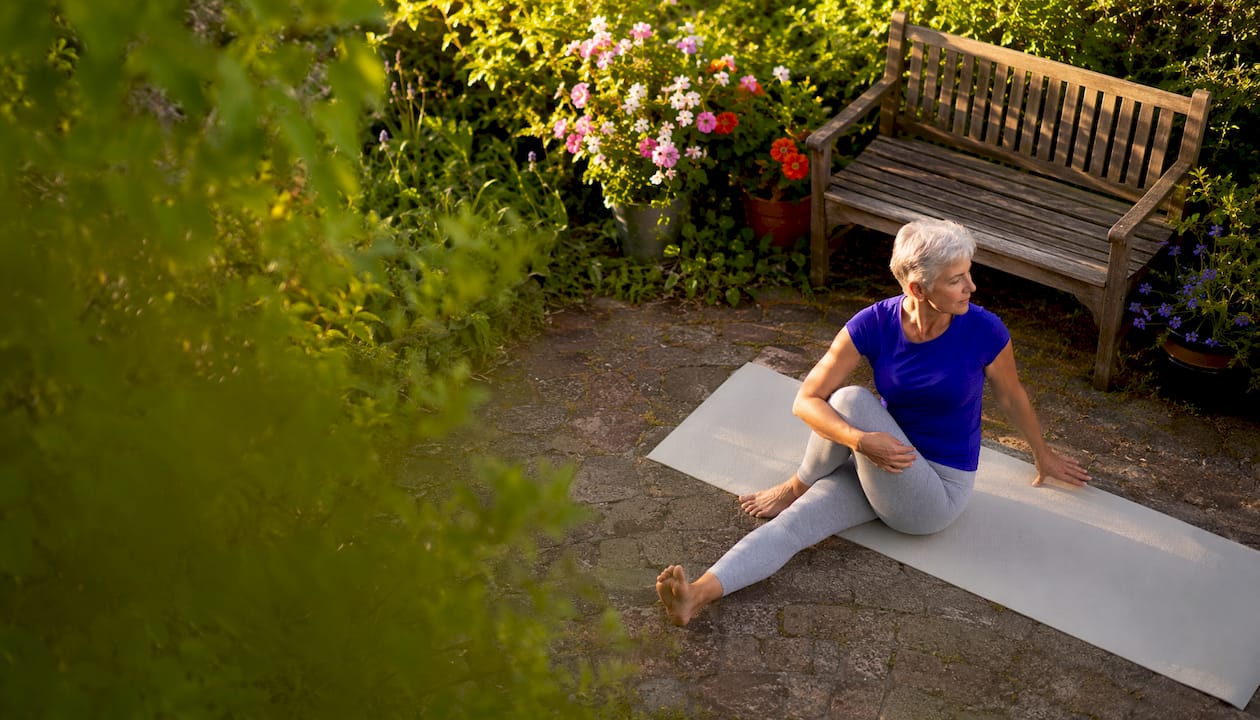 Eine ältere Dame genießt ihre Yogaübungen, um Körper und Geist zu entspannen.