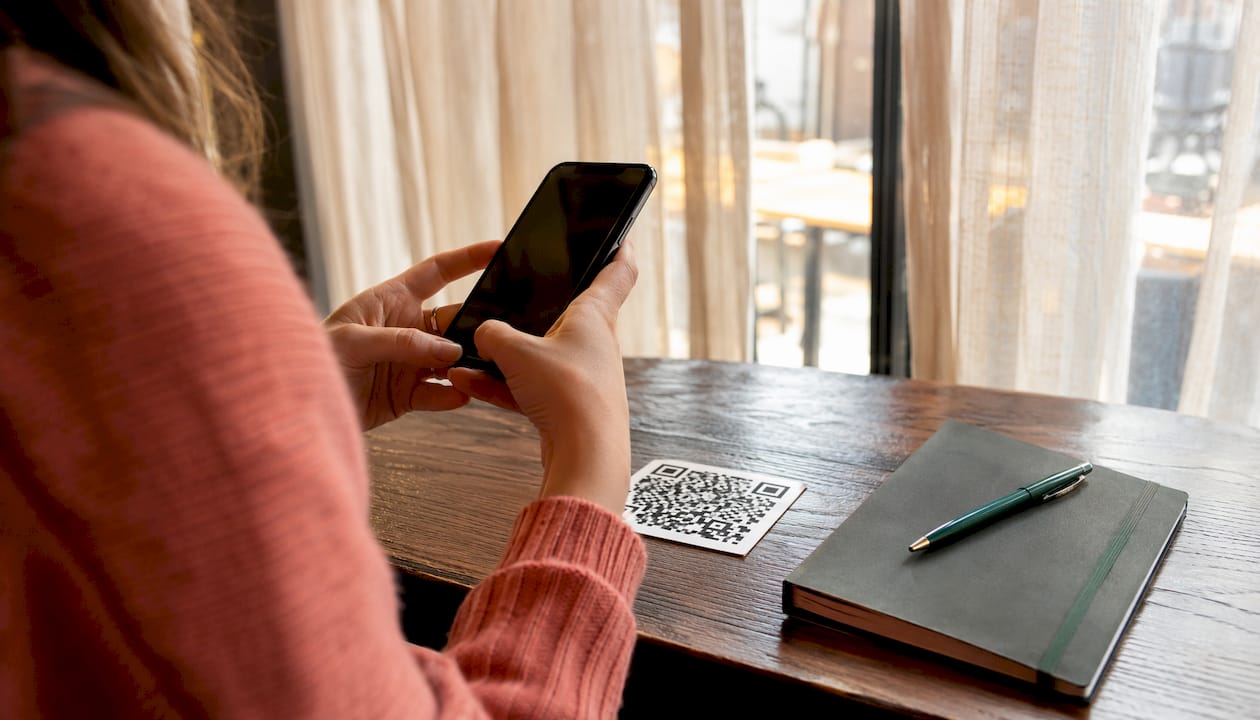 Une personne utilise son smartphone pour flasher un QR code