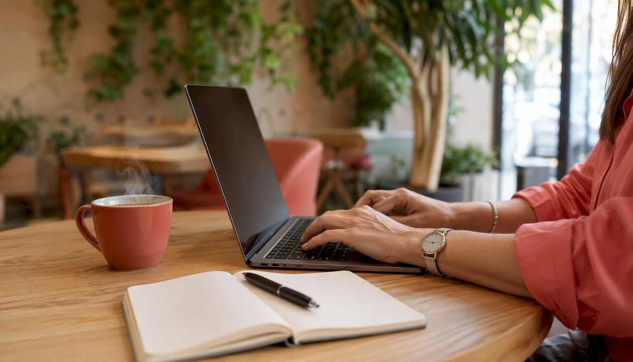 Zoom sur des mains en train de taper sur le clavier d’un ordinateur portable.