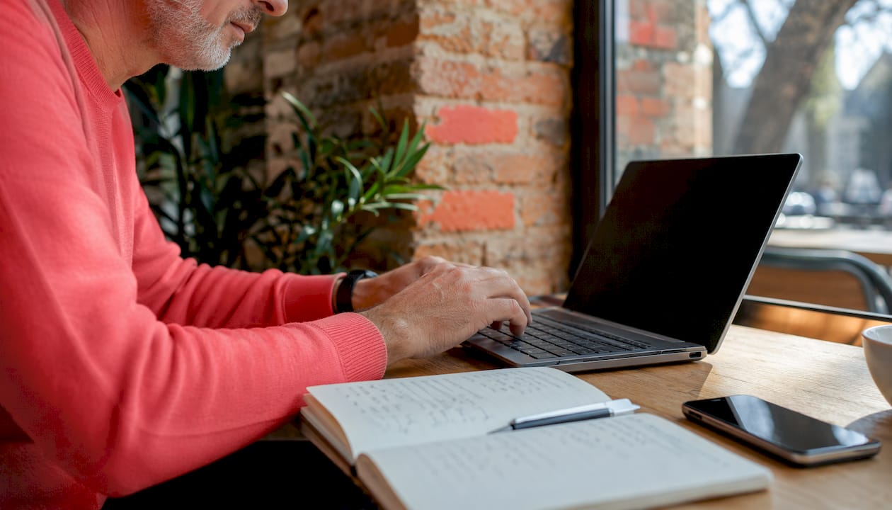Des mains s’activent sur un clavier, naviguant sur une plateforme dédiée à un livret numérique.