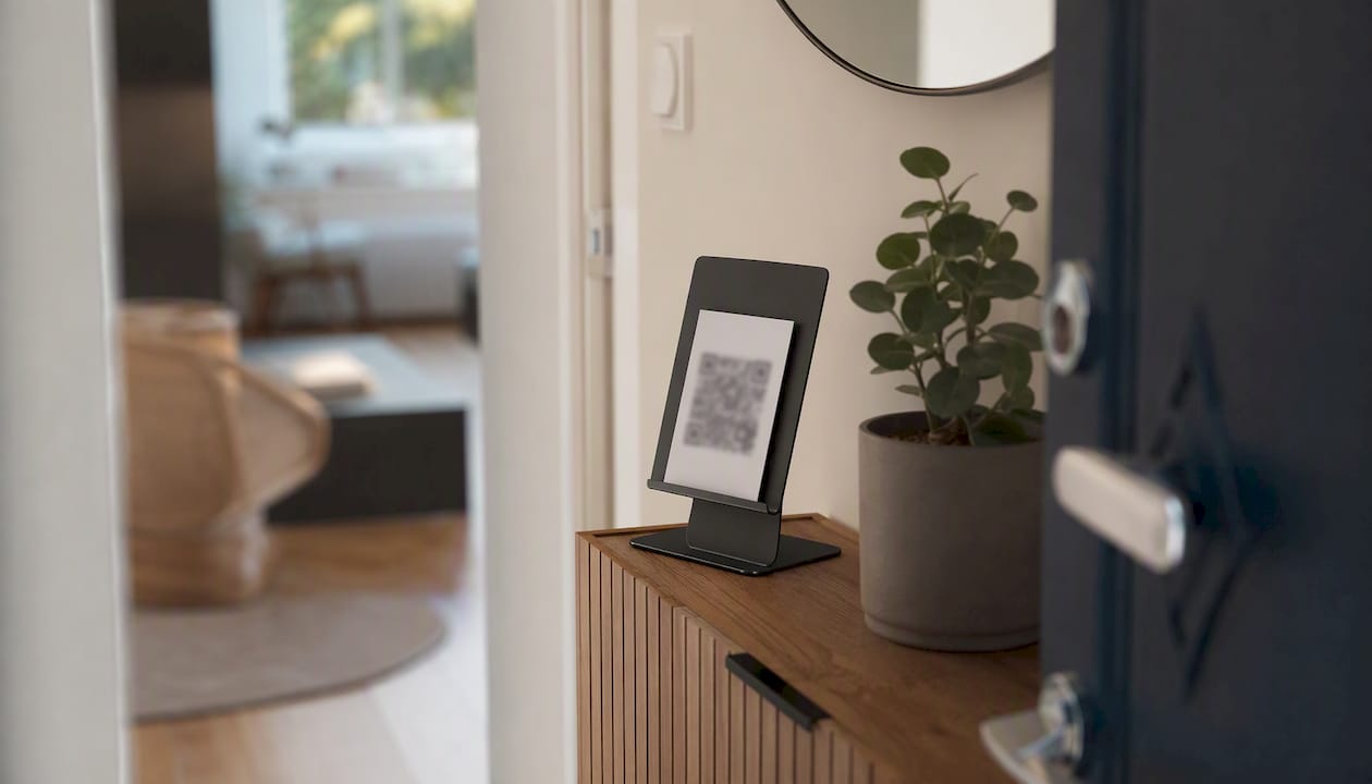 Une carte avec un QR code est disposée sur un présentoir à l’entrée de l’appartement.