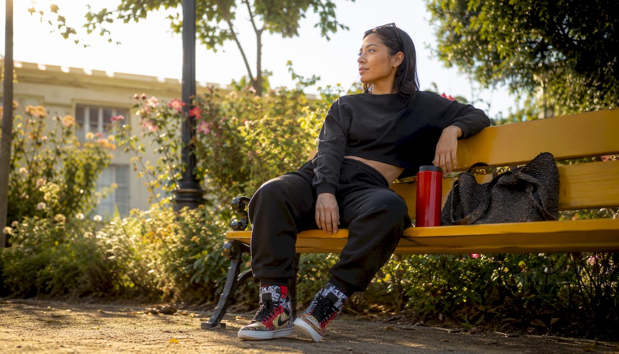 Woman sitting in matching sweatsuit with colorful sneakers