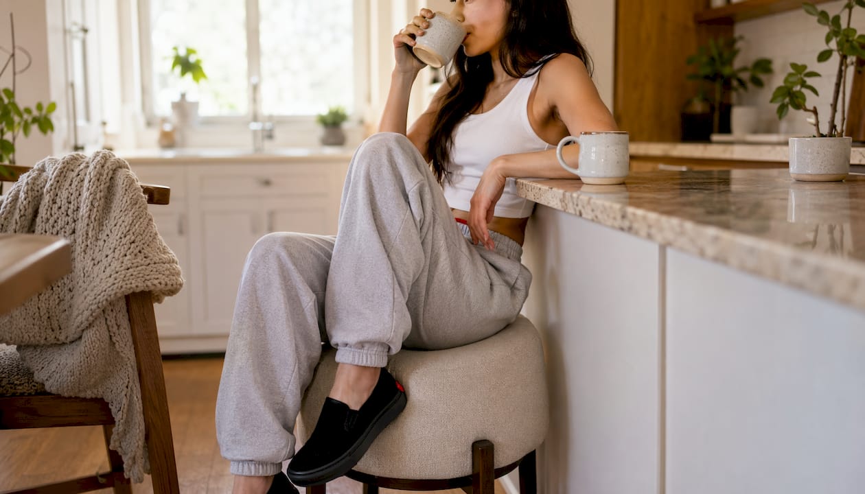 Woman styling uncuffed sweatpants at home