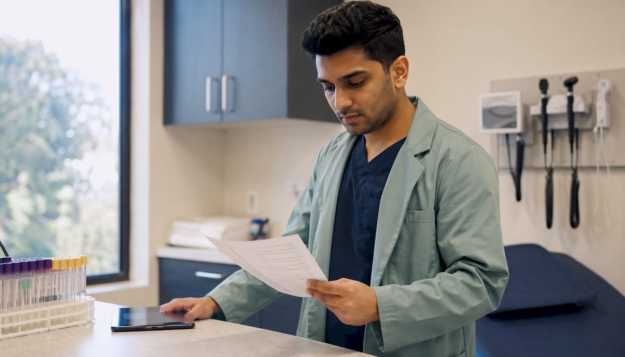 Hands reviewing E/M coding checklist in urgent care