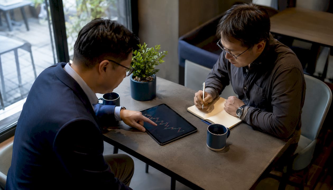 Businessmen discussing market cap reports