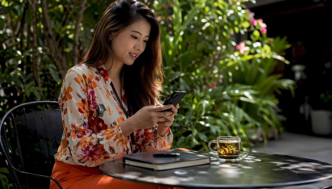 Personalmanagerin verfasst eine Nachricht zur Mitarbeitersuche auf dem Smartphone.
