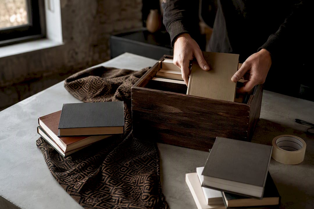 Hands packing books into shipping box