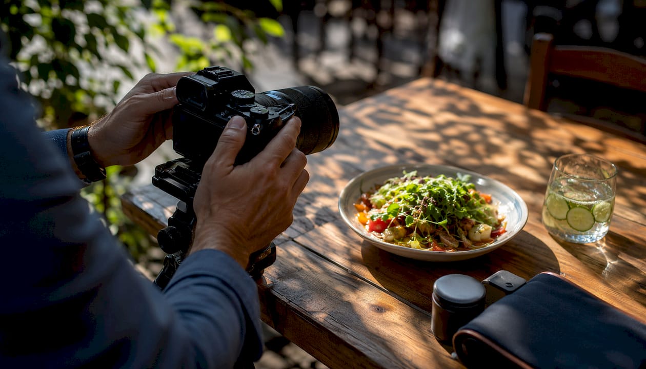 Photographer adjusting camera for restaurant dish photo