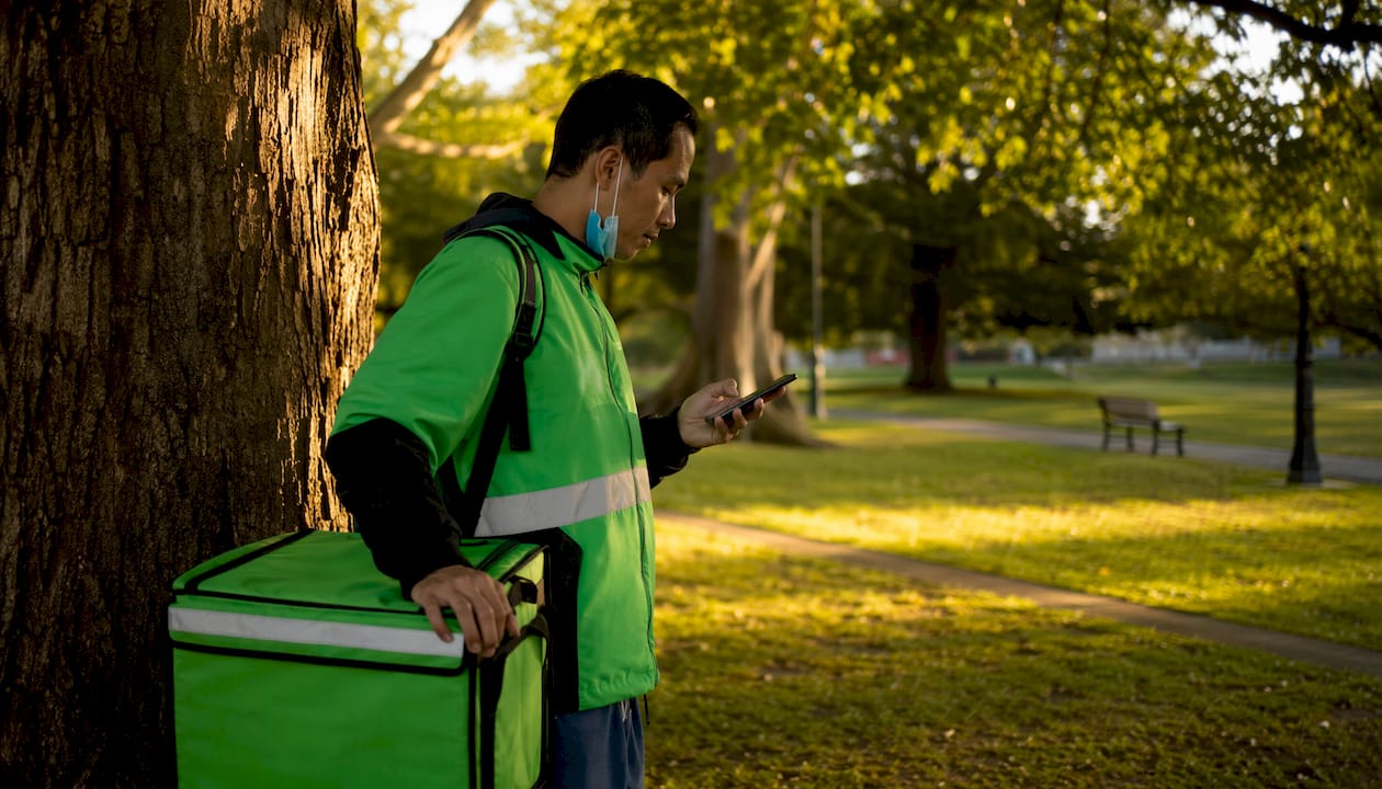UberEats delivery courier using smartphone outdoors