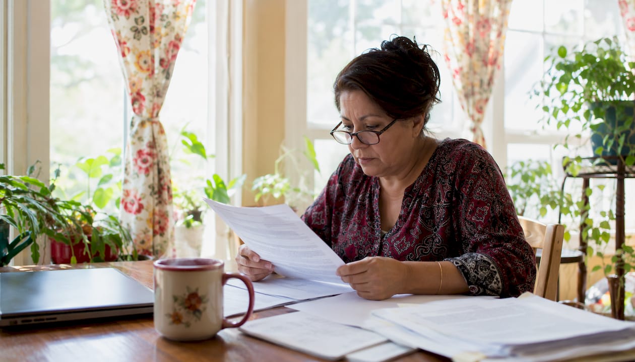 Latina woman reviewing wrongful termination papers at home