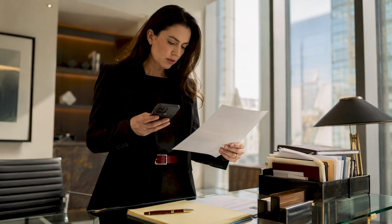 Professional reviewing text message evidence at desk